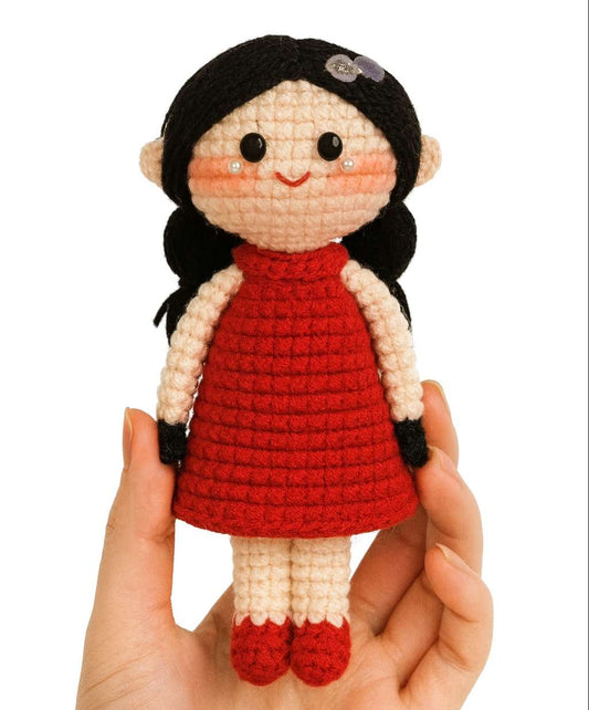 Poupée amigurumi au crochet avec robe fleurie et tresses noires
