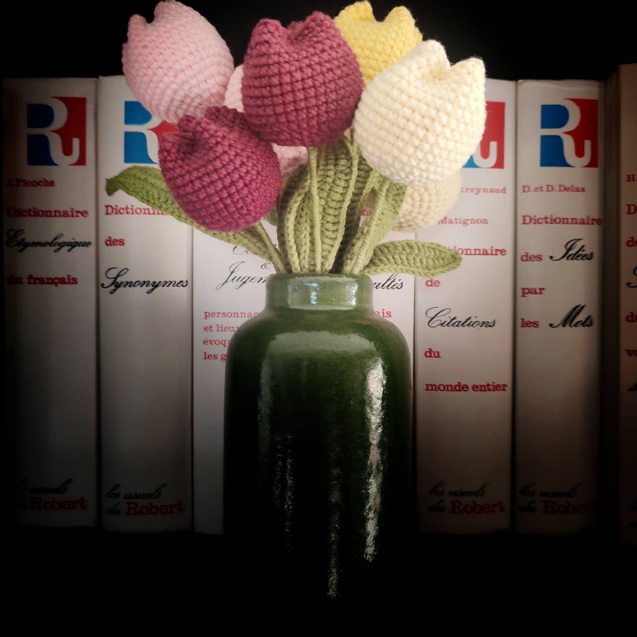 Fleurs en crochet : tulipes colorées avec feuilles vertes, prêtes à être assemblées.